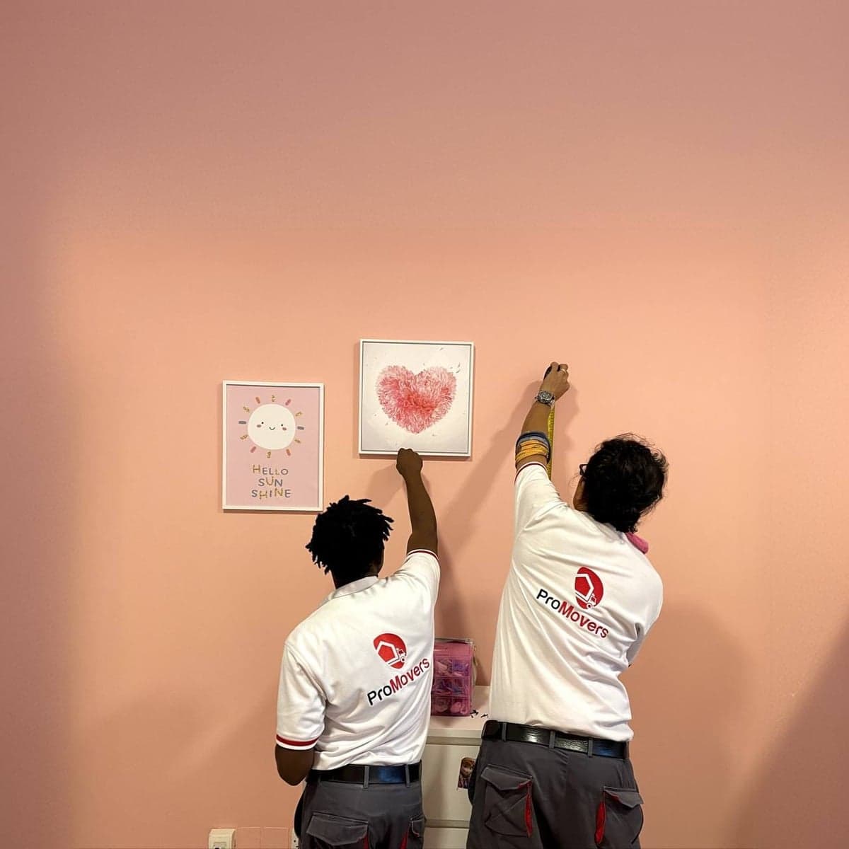 ProMovers team hanging artwork in a child's bedroom